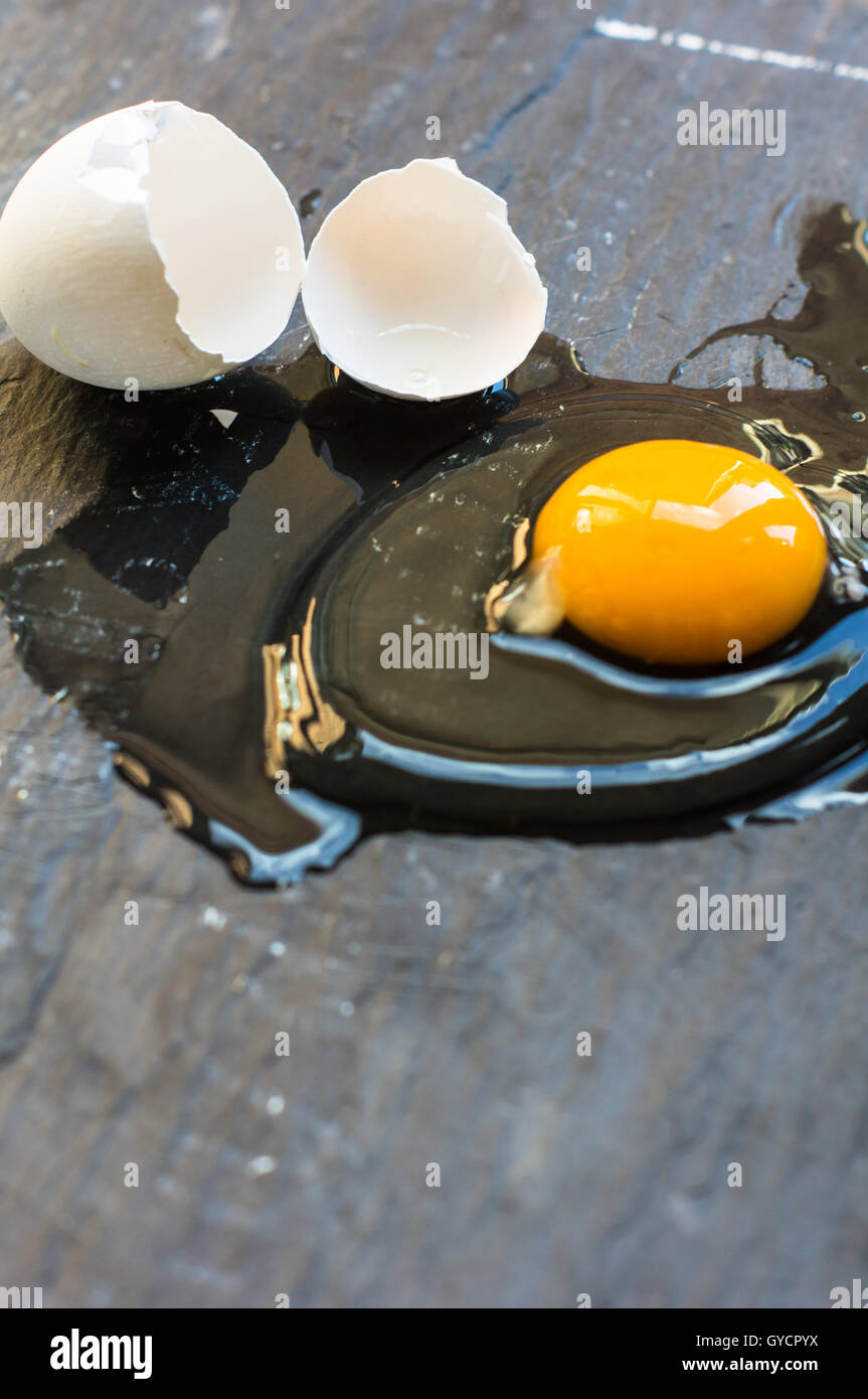 Raw broken egg on dark background Stock Photo - Alamy