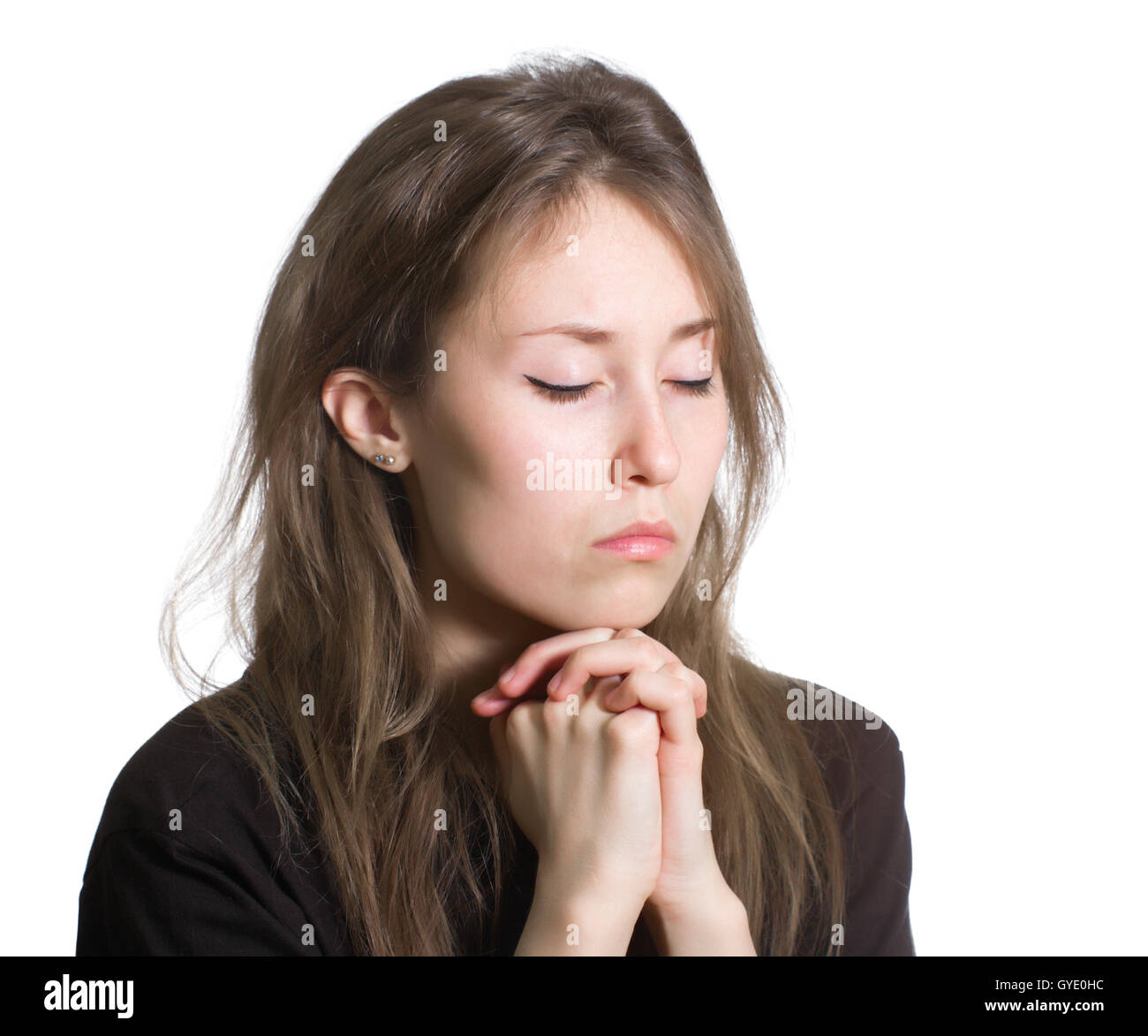 Portrait of an attractive beautiful pretty cute young caucasian woman (lady, girl, female, person) dressed black and praying Stock Photo