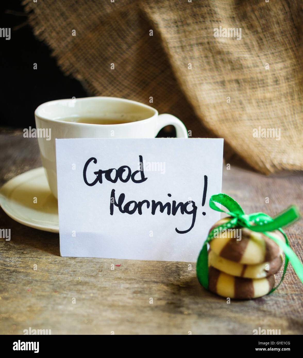Cup of green tea, Good morning note and cookies on the table Stock Photo