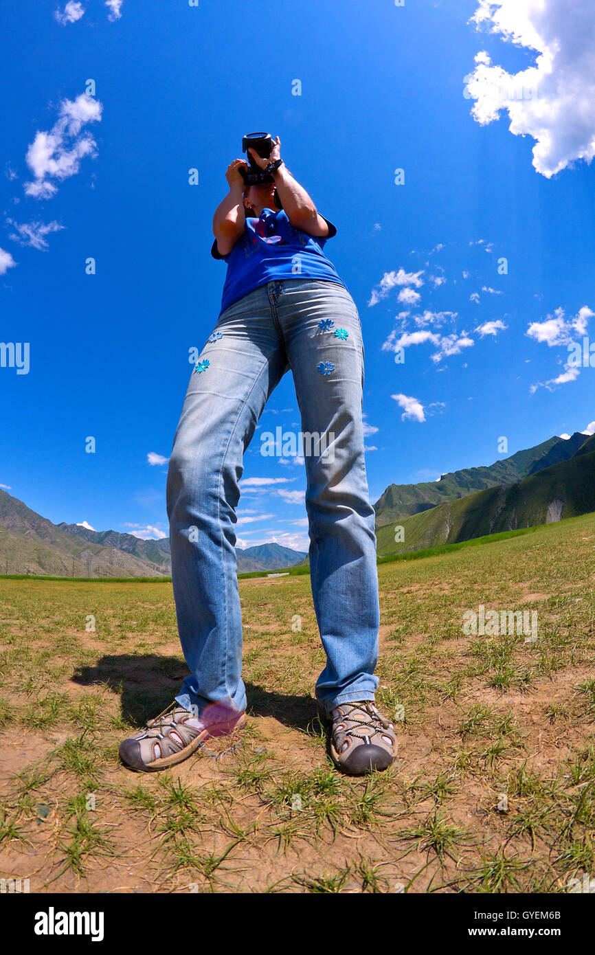 Portrait of nature photographer woman taking landscape pictures in the mountain area (Altai, Russia). Stock Photo