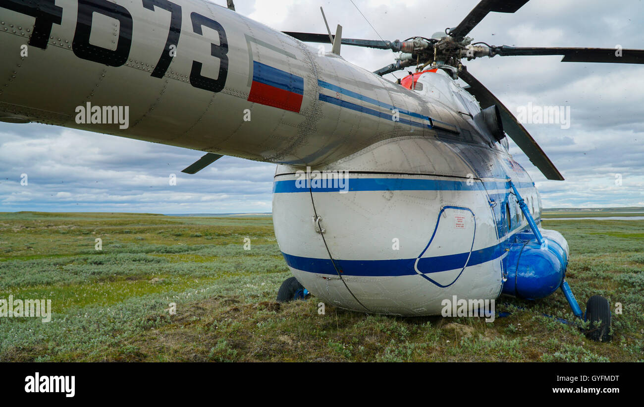 YAMAL PENINSULA, RUSSIA - JUNE 18, 2015: Helicopter expedition to the giant funnel of unknown origin. The helicopter MI-8. Stock Photo
