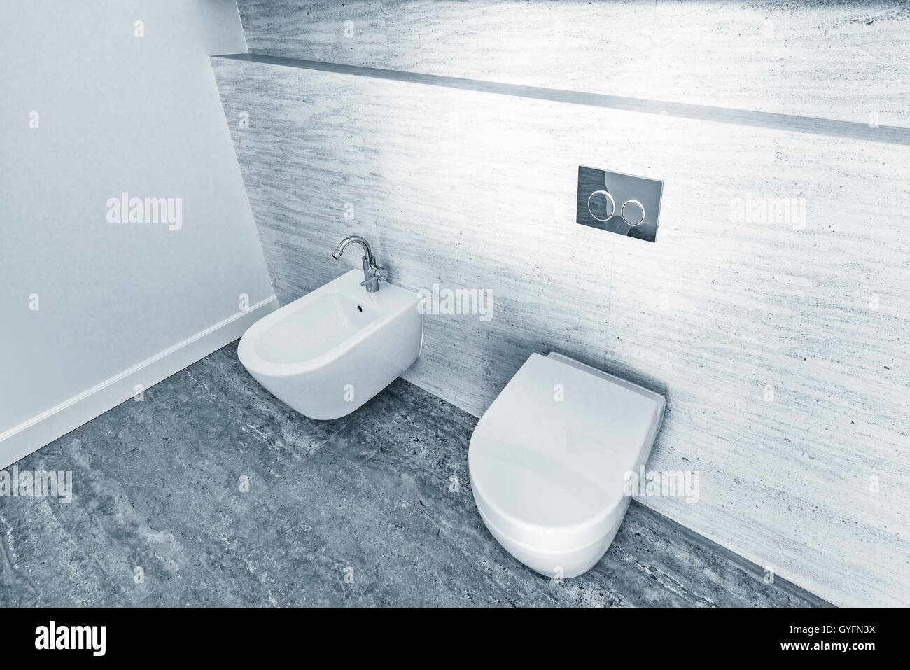Two white closed toilet bowls in the bathroom Stock Photo Alamy