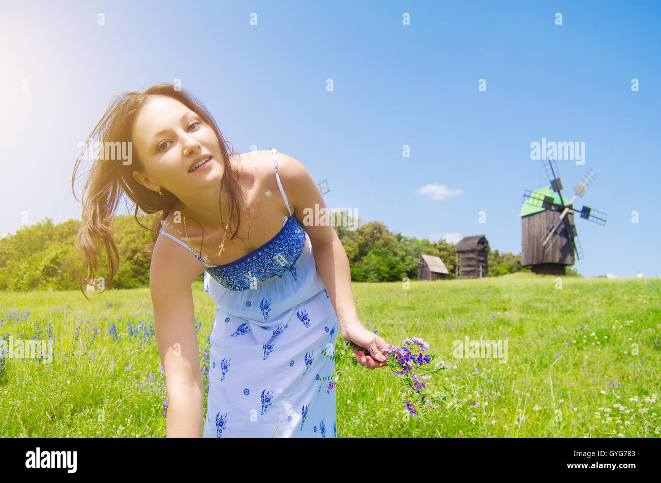 girl walking on the field with a bouquet of flowers Stock Photo