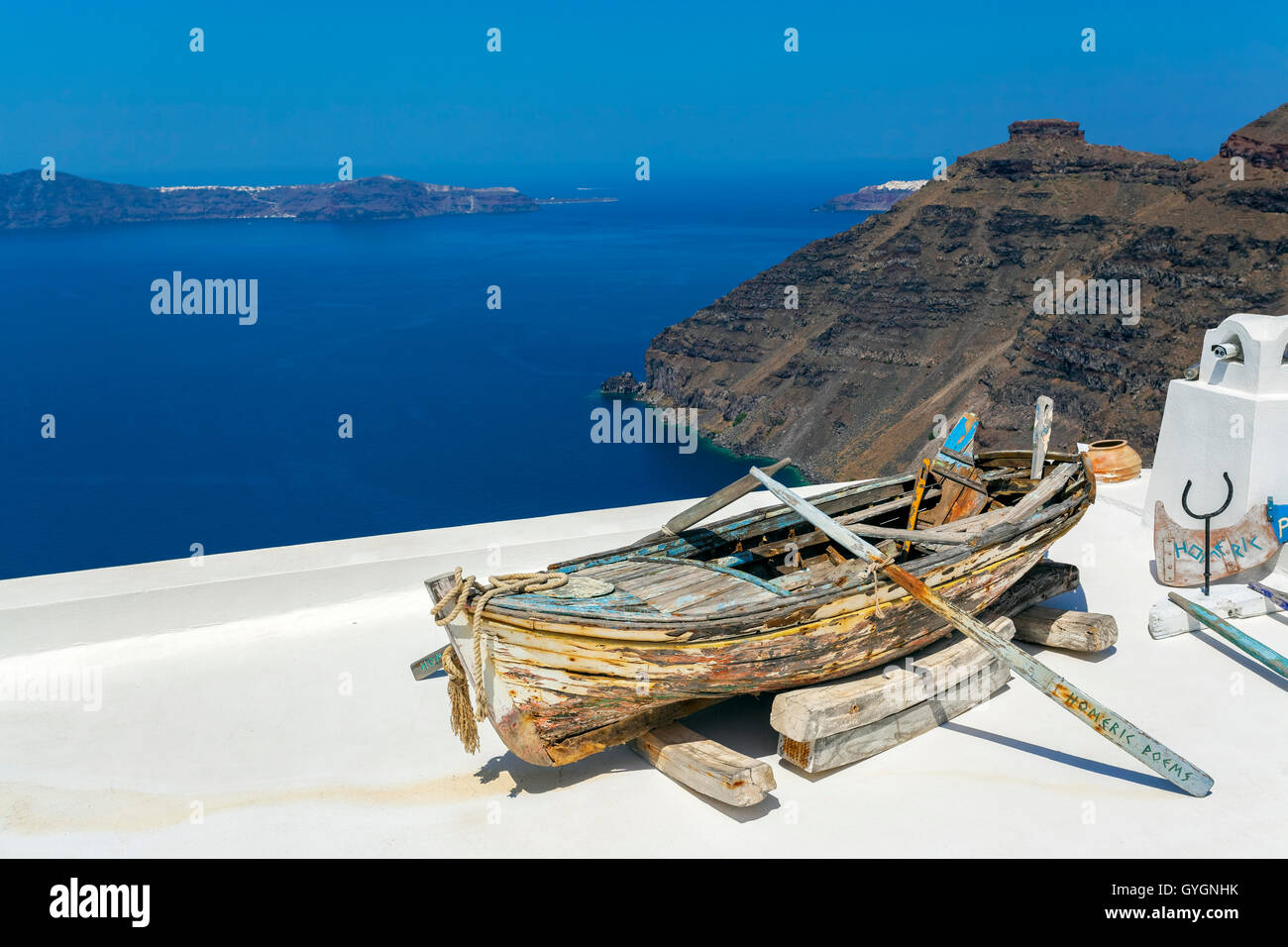 Old Boat with the Caldera scenic view on the backgound in Thira, Fira, Santorini, Cyclades Islands, Greece Stock Photo