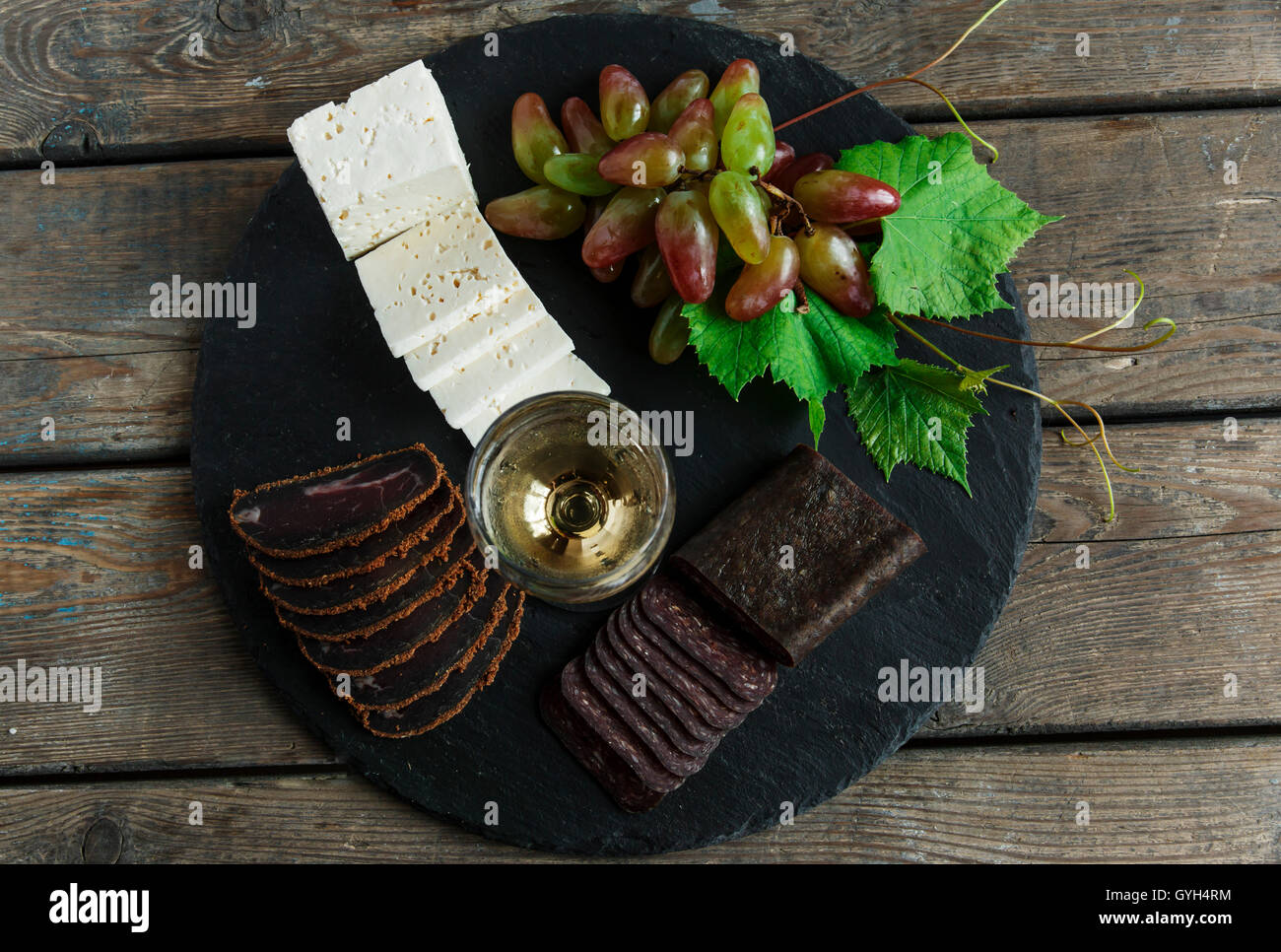 wine grapes cheese jerky basturma on black stone Stock Photo