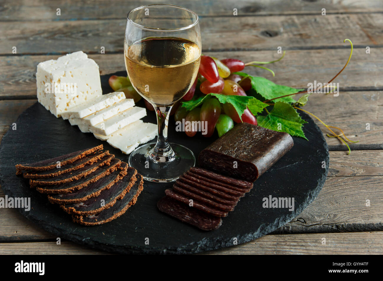 wine grapes cheese jerky basturma on black stone Stock Photo