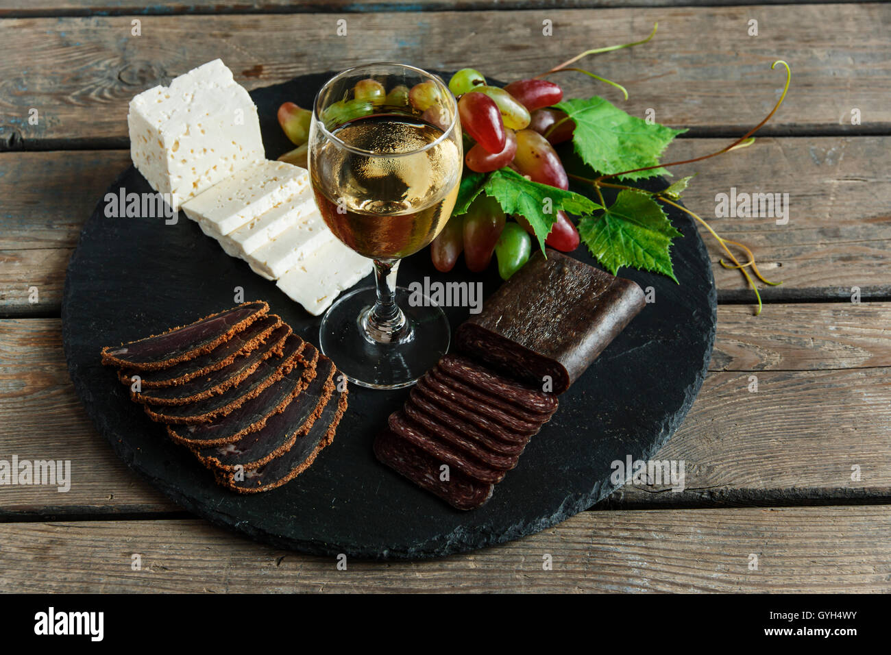 wine grapes cheese jerky basturma on black stone Stock Photo Alamy