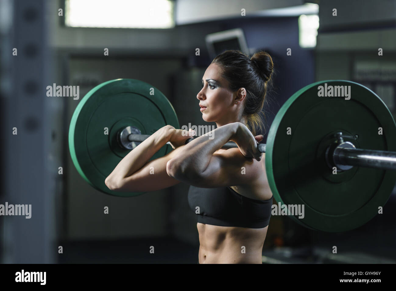 Concept: power, strength, healthy lifestyle, sport. Powerful attractive muscular woman CrossFit trainer do workout with barbell  Stock Photo
