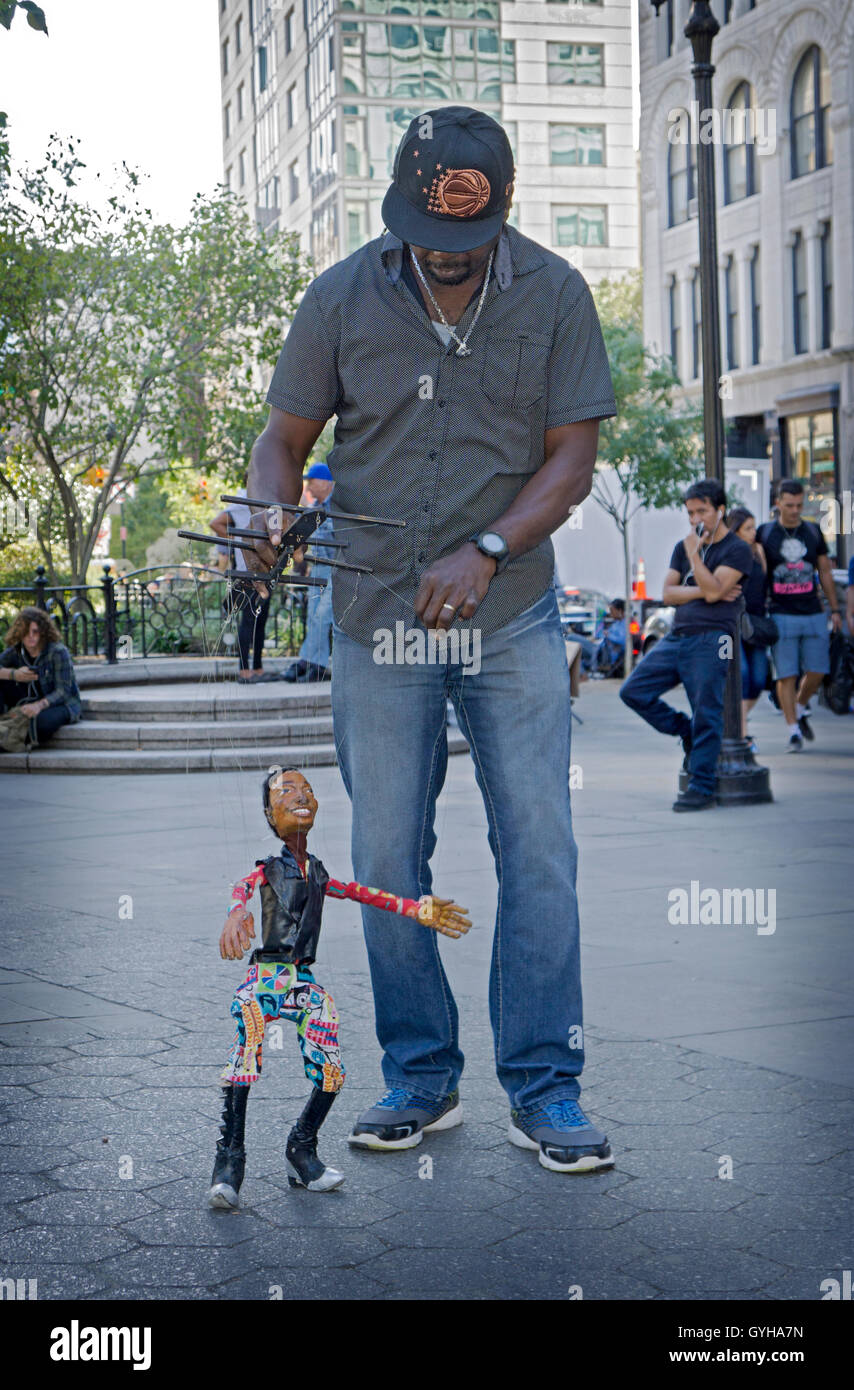 A marionette puppeteer with his dancing puppet in Union Square Park in Manhattan, New York City Stock Photo