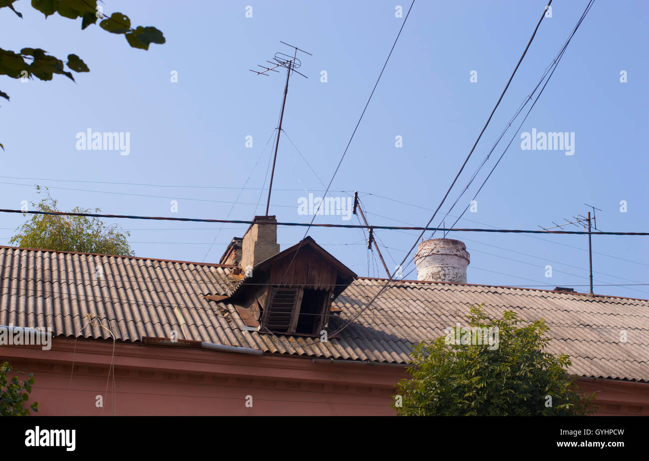 Rustic Dormer on Slate Roof Beneath Blue Sky Stock Photo