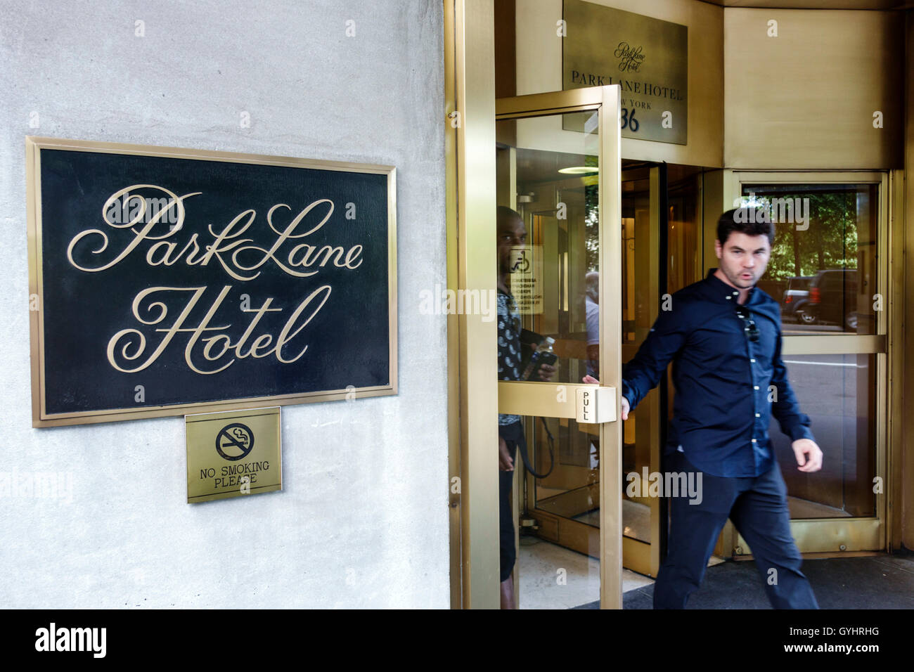 New York City,NY NYC Manhattan,Central Park South,Park Lane Hotel,hotel,lodging,front,entrance,door,adult,adults,man men male,exiting,sign,no smoking, Stock Photo
