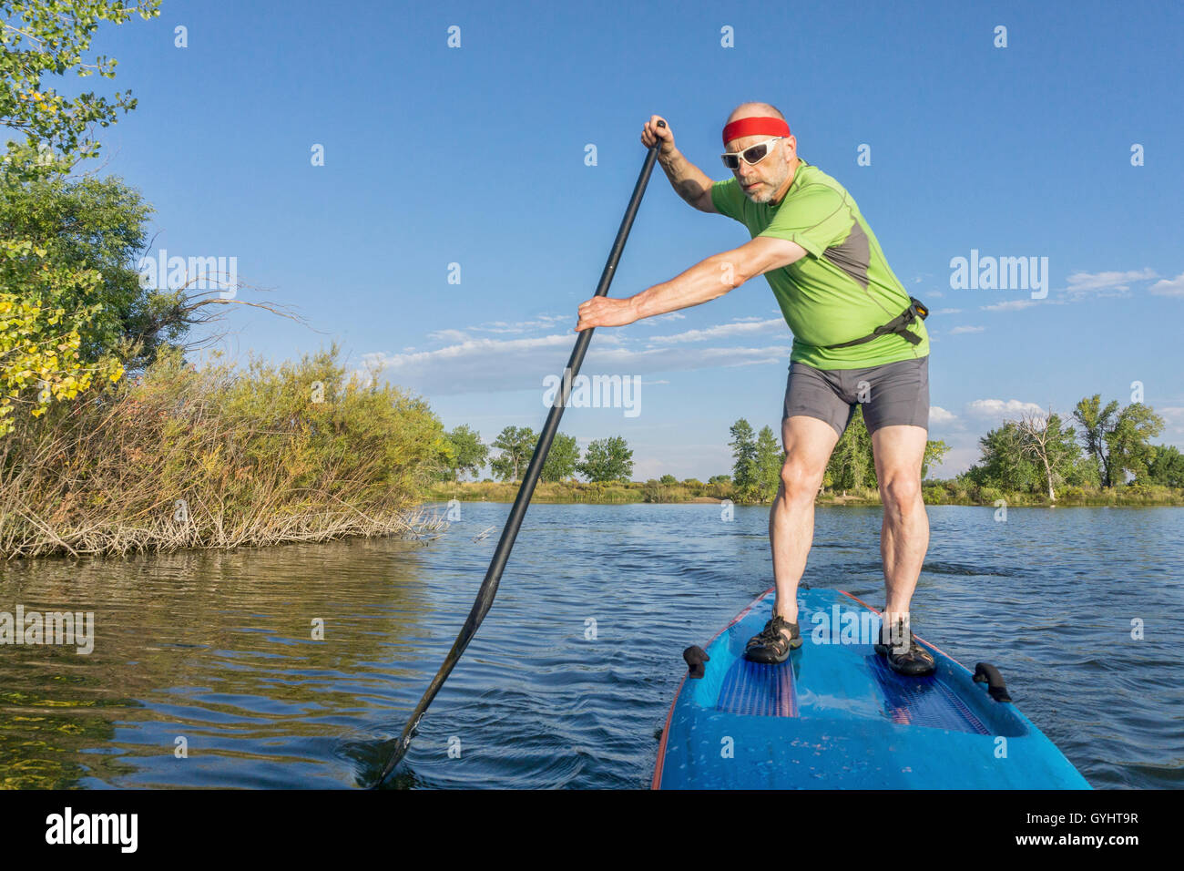 muscular, senior male paddler on a stand up paddleboard on a lake in Colorado Stock Photo