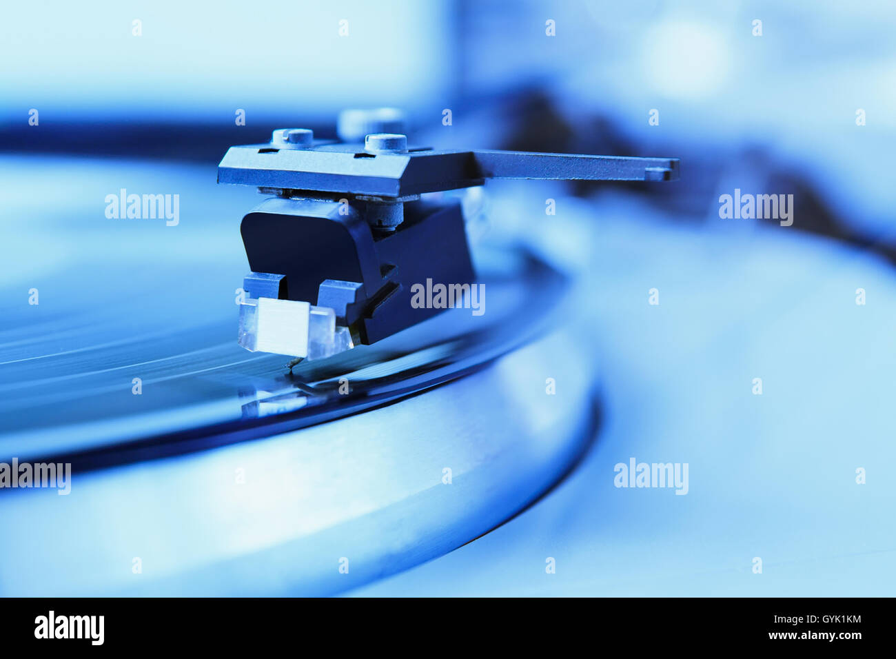 Turntable analog record player playing vinyl disc with music. Focus on the needle. Stock Photo