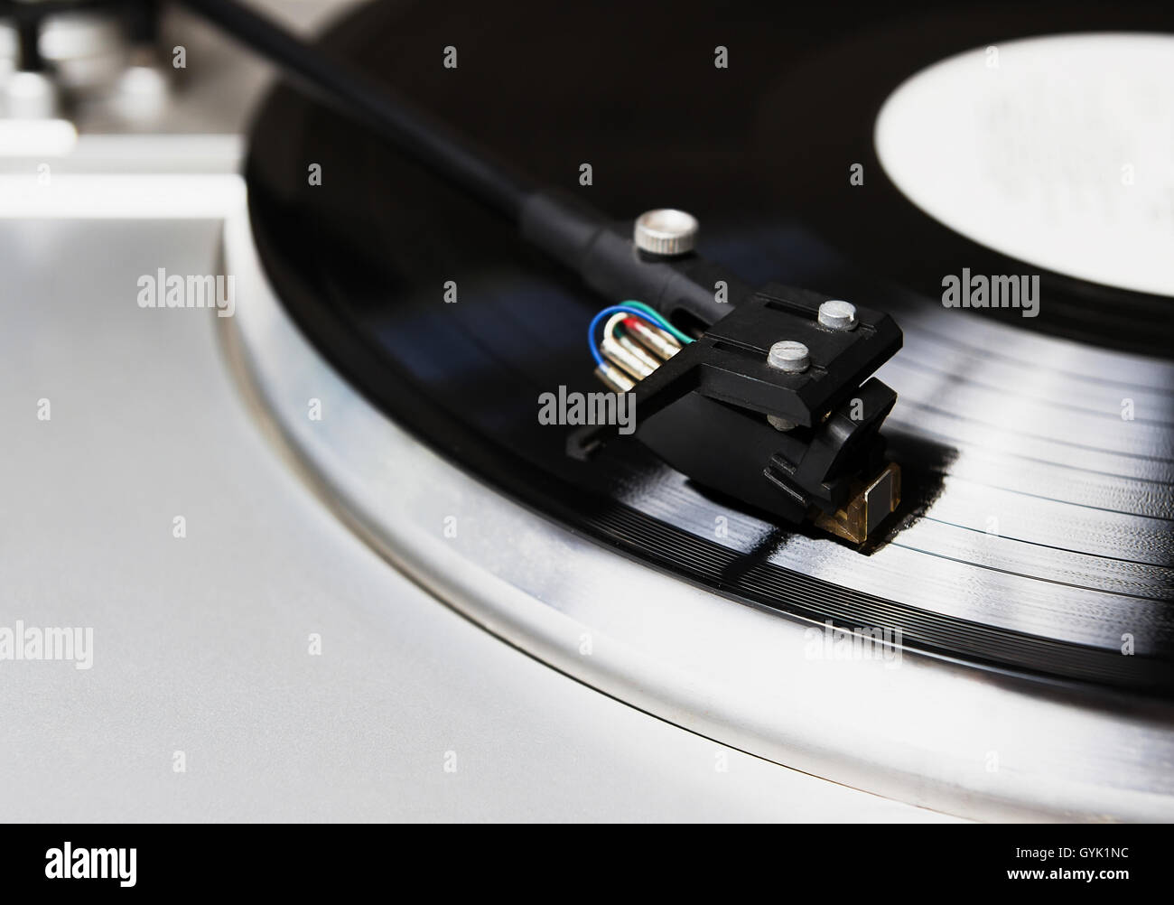 Turntable playing vinyl record with music. Useful equipment for DJ, nightclub and retro hipster theme or audio enthusiast. Stock Photo