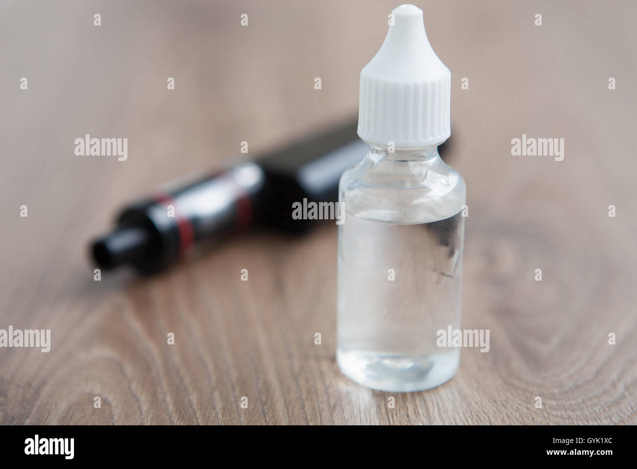 E-juice for e-cig and vaping device. Vaporizer and tasty filling e-liquid. Refill liquid tobacco with propylen glicol and glycerin base. Place text on transparent bottle. Stock Photo