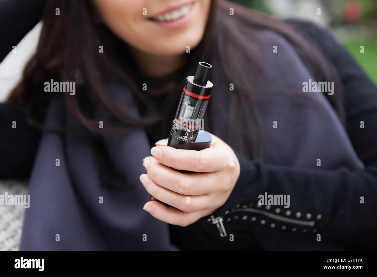 Trendy gadget vaporizer device in female hands.Quist smoking nicotine