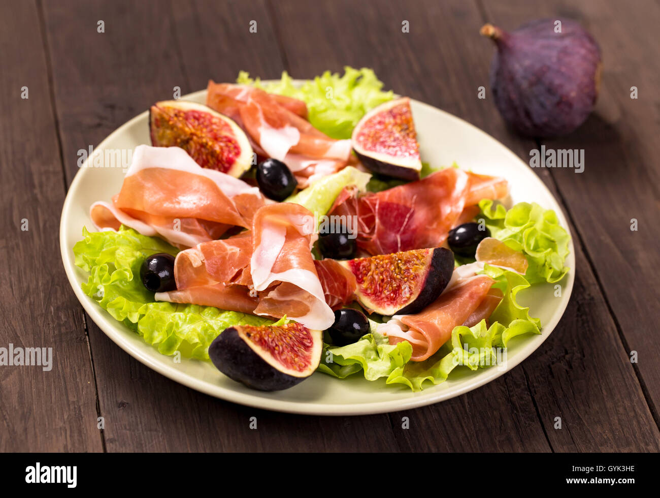 Prosciutto with figs, olives and arugula Stock Photo