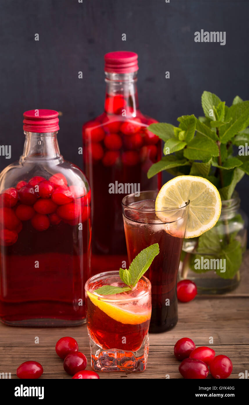 Shots and bottles of cranberry beverage Stock Photo