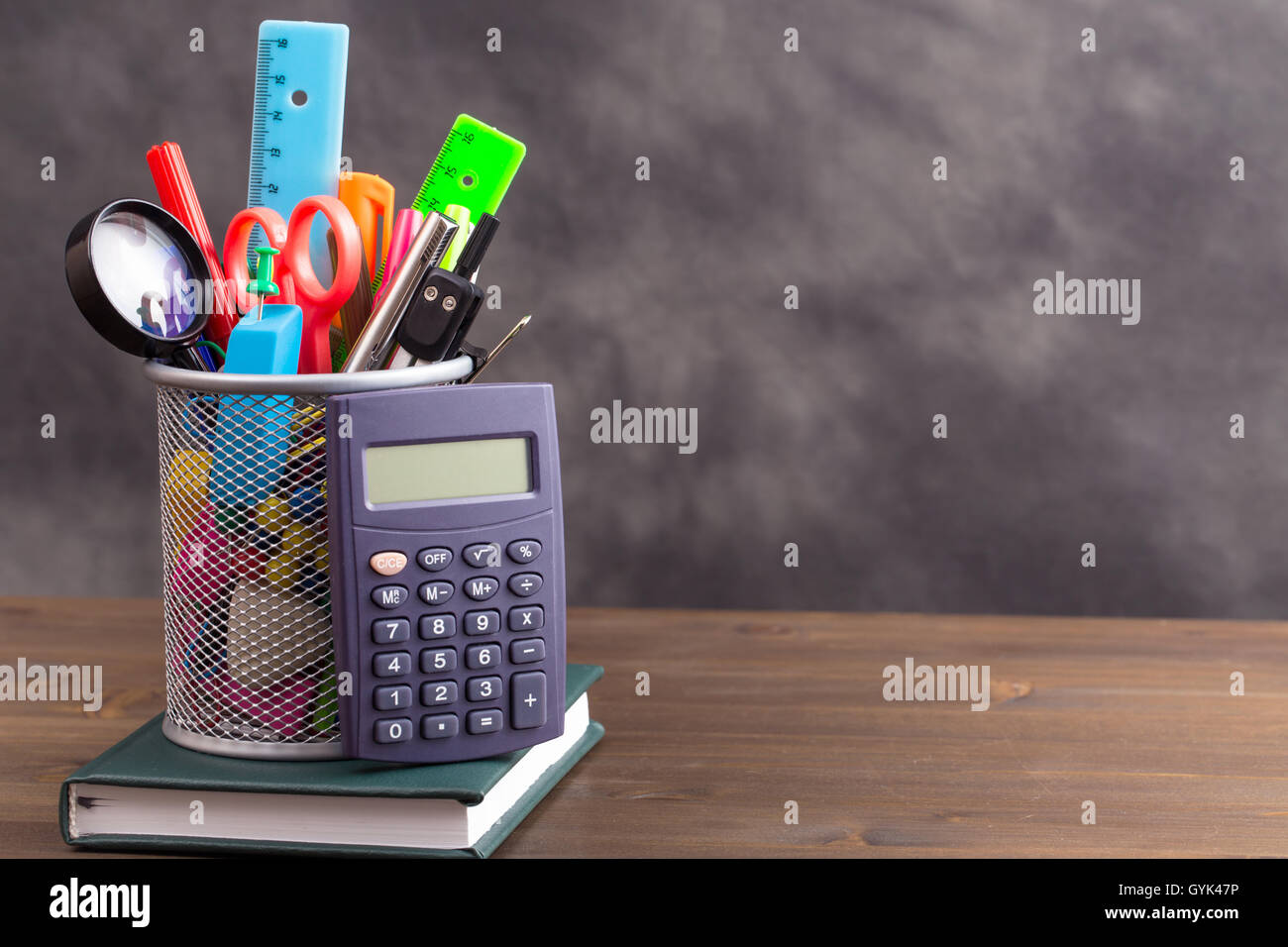 Stationery items with calculator at left side on wooden table Stock Photo