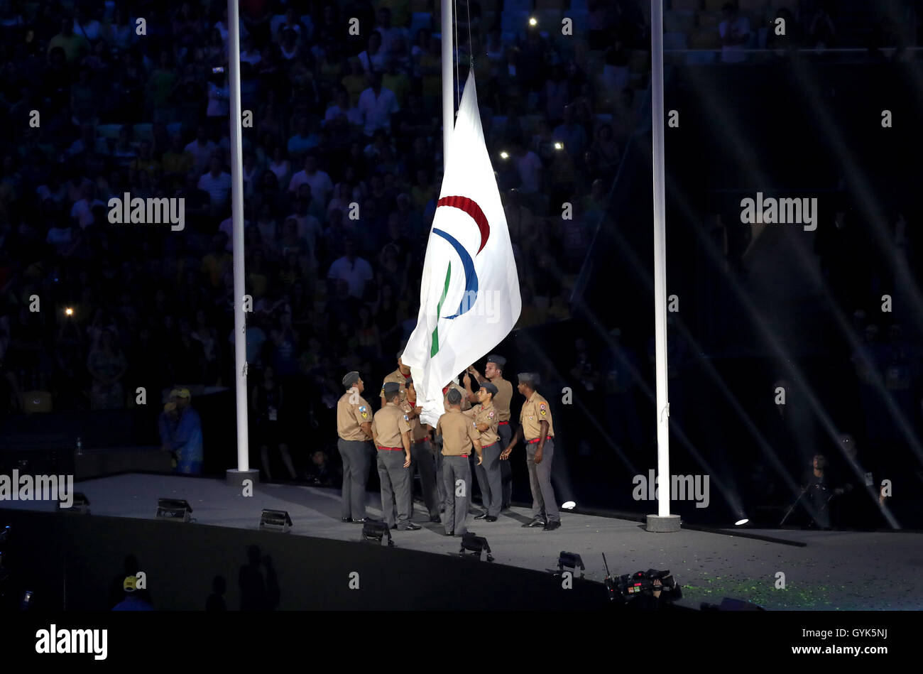 The Paralympic flag is lowered by soldiers during the closing ceremony on the eleventh day of the 2016 Rio Paralympic Games at the Maracana, Rio de Janeiro, Brazil. Stock Photo