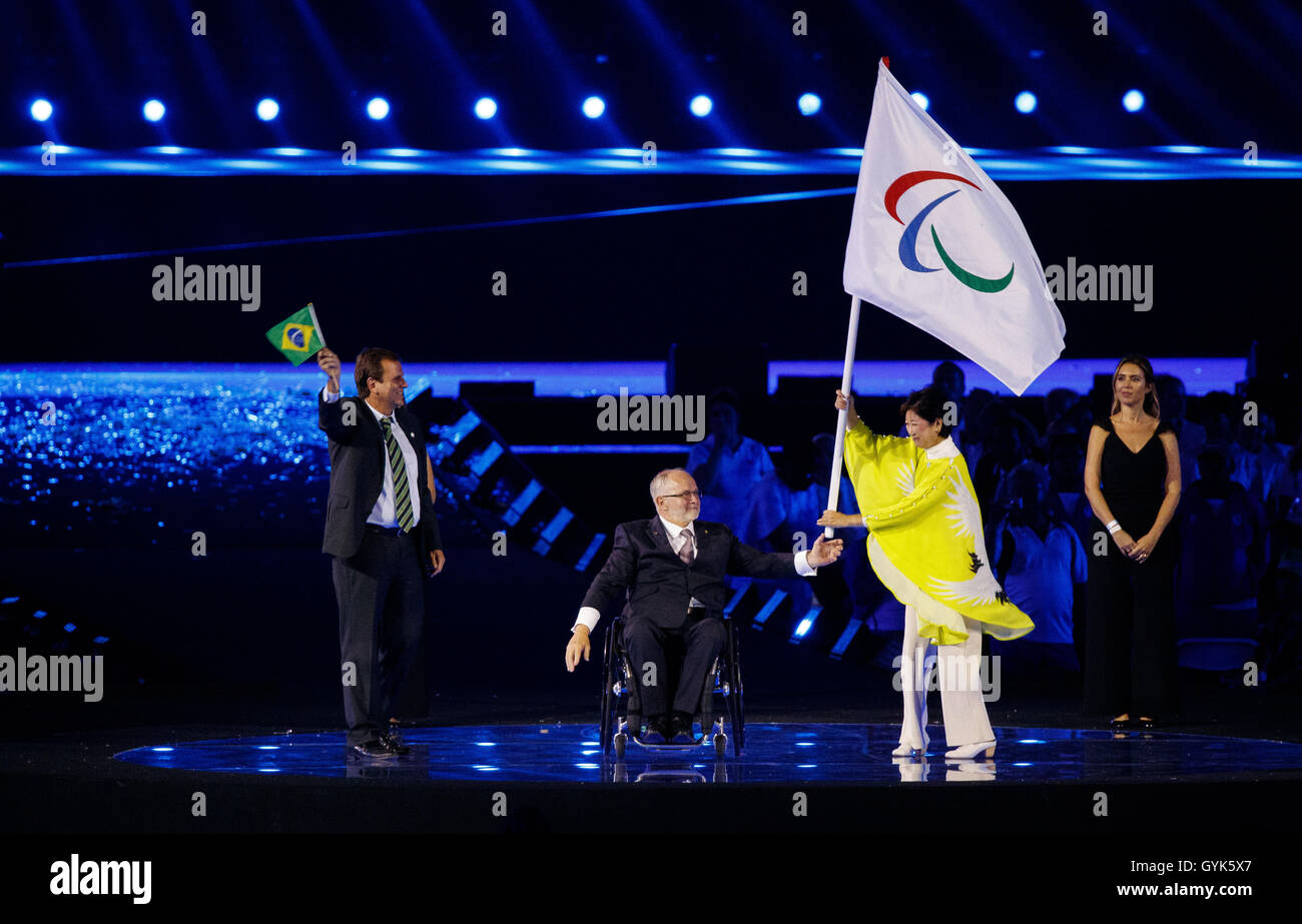 The Mayor of Rio de Janeiro Eduardo Paes (left) applauds as President of the IPC Sir Philip Craven (centre) hands the Paralympic flag to the Governor of Tokyo Yuriko Koike during the eleventh day of the 2016 Rio Paralympic Games in Rio de Janeiro, Brazil. Stock Photo