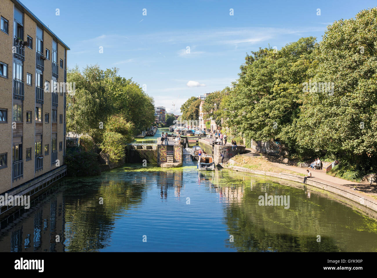 View of Regent's canal from a bridge near Broadway market with boats and people walking next to it . Stock Photo