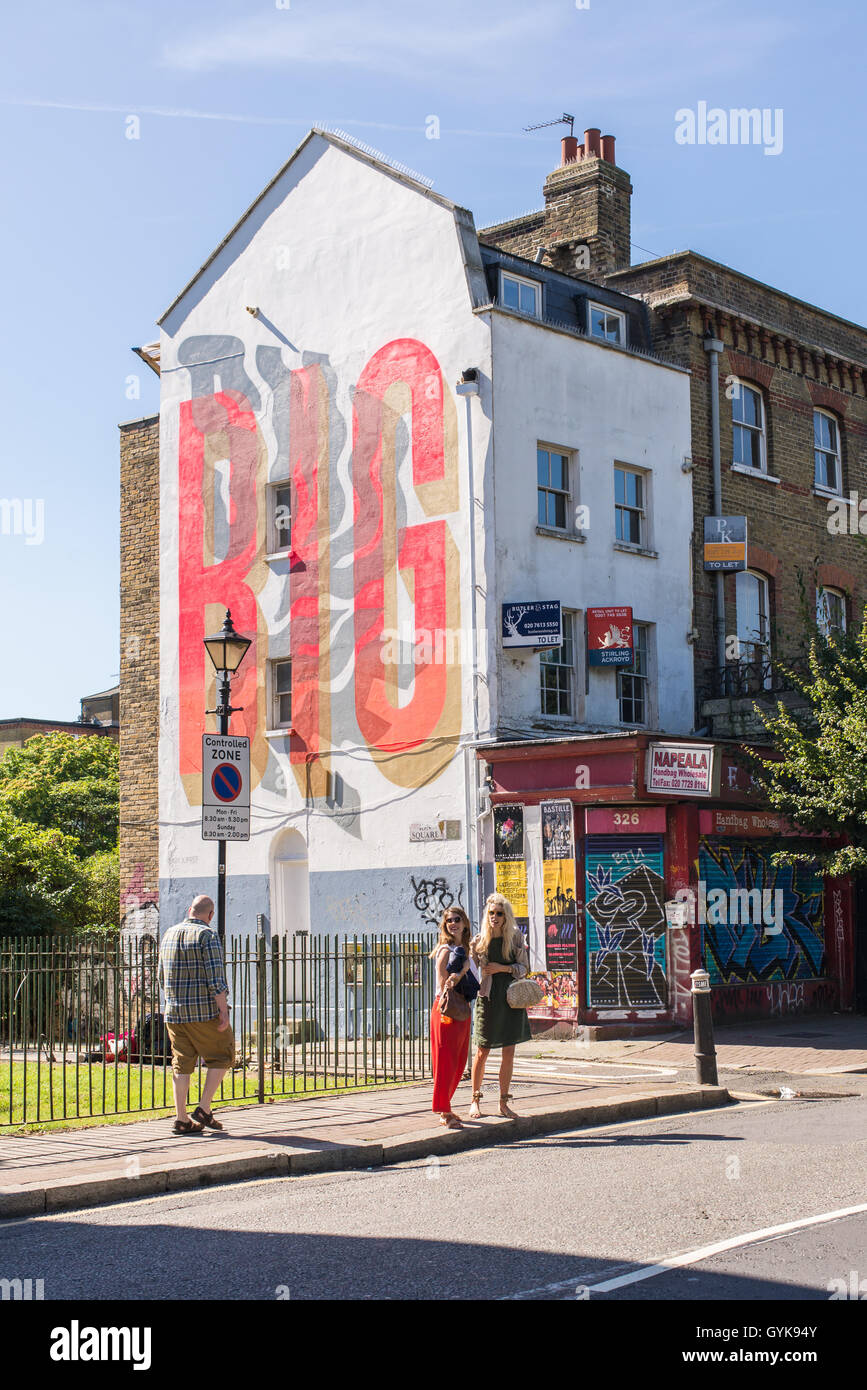 People walking on Hackney road in Bethnal Green, East London, on a sunny day. Stock Photo