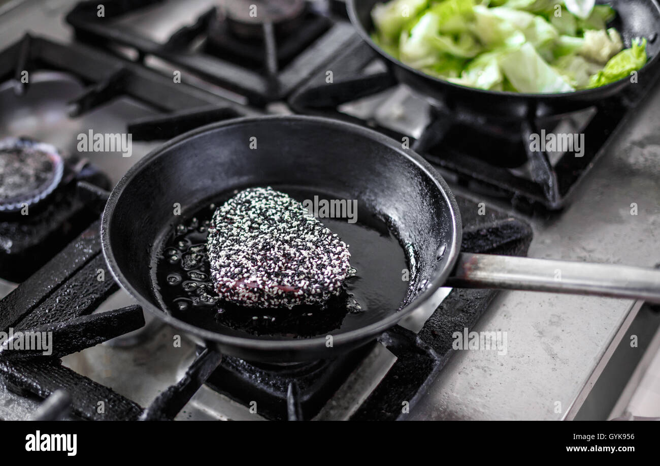 Red tuna steak being fried on olive oil on pan Stock Photo