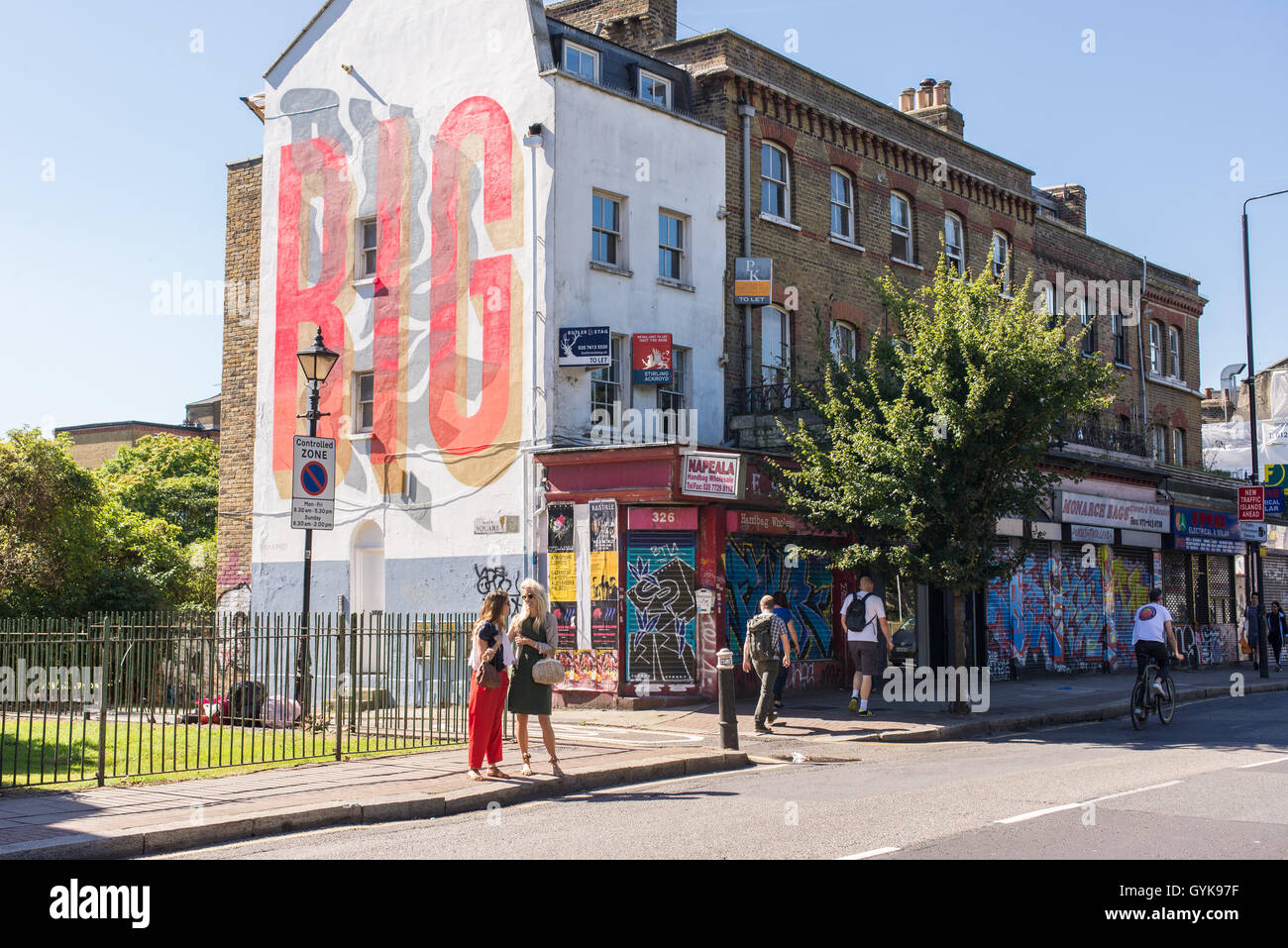 People walking on Hackney road in Bethnal Green, East London, on a sunny day. Stock Photo