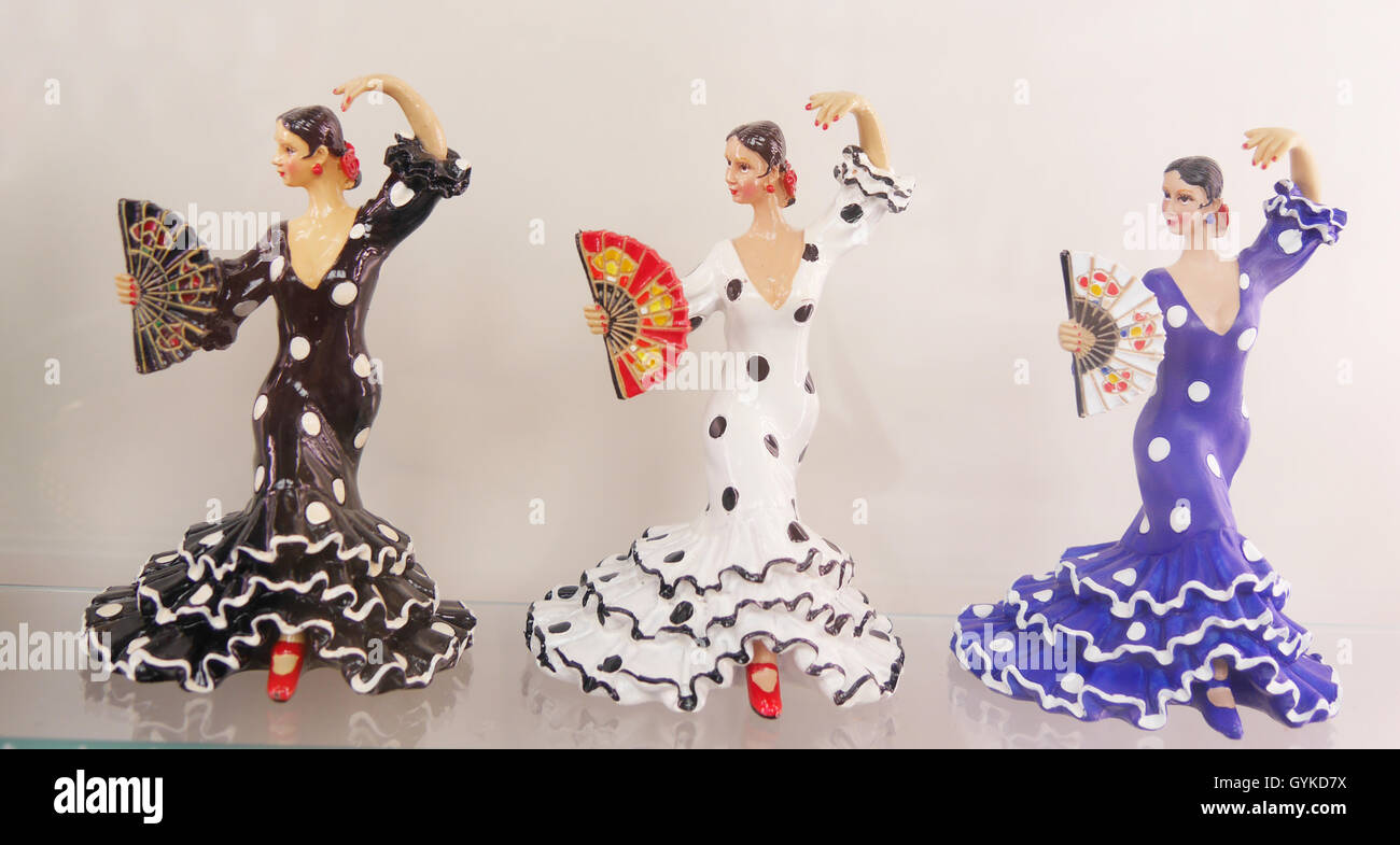 Row of three porcelain souvenir figures of flamenco dancers in an elegant dance position, with spotted dresses and fans Stock Photo