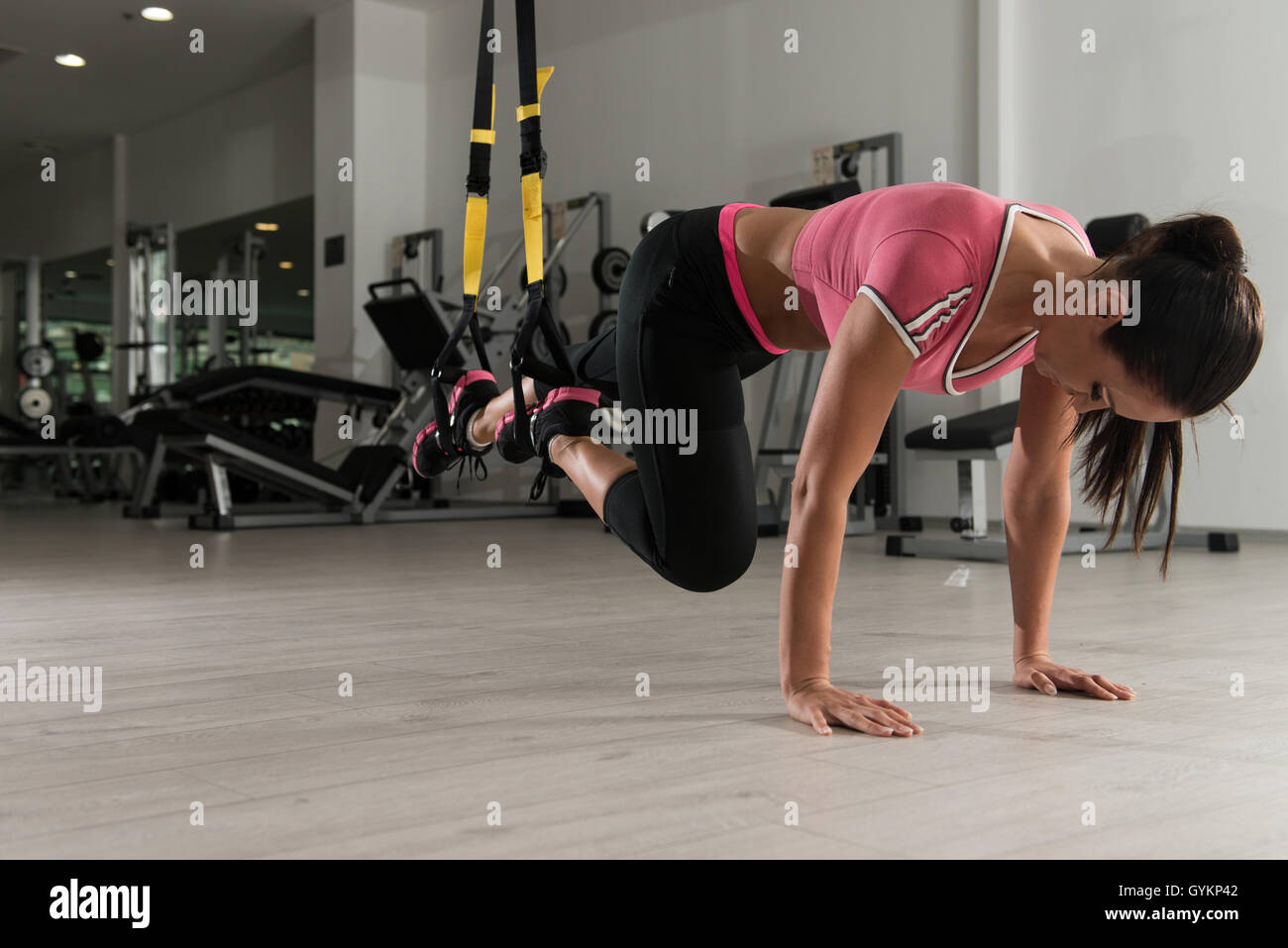 Attractive Woman Does Crossfit With Trx Fitness Straps In The Gym's Studio Stock Photo