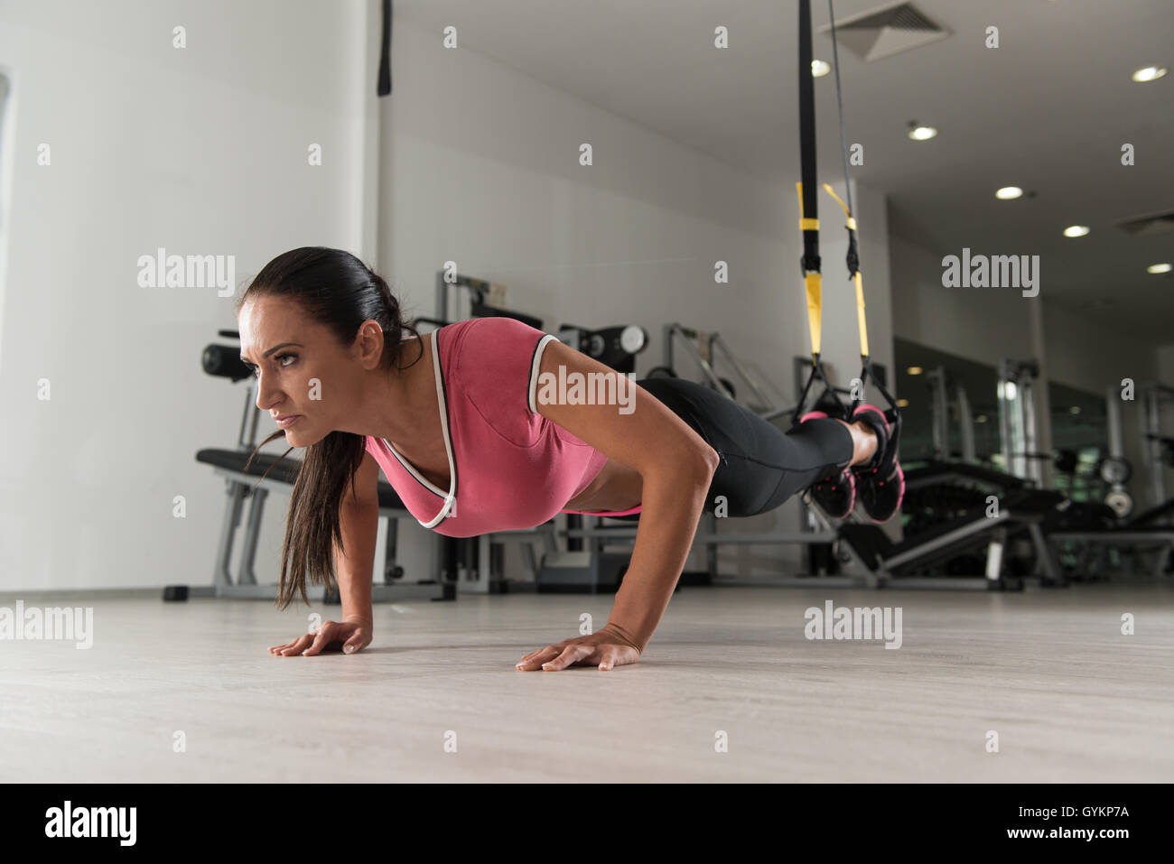 Attractive Woman Does Crossfit With Trx Fitness Straps In The Gym's Studio Stock Photo
