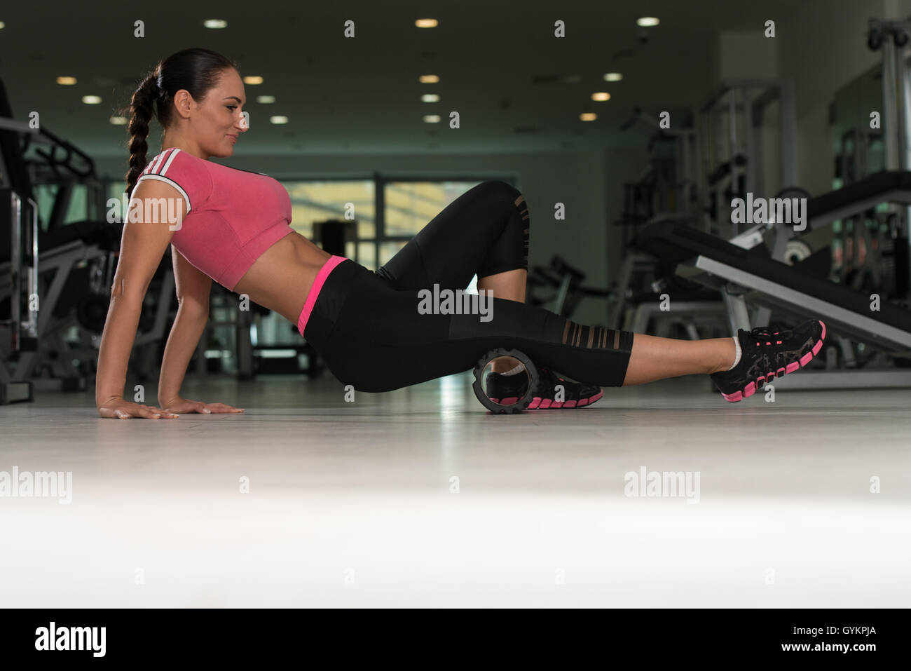 Attractive Woman Exercising With Wheel Roller For Legs On Floor In Gym ...