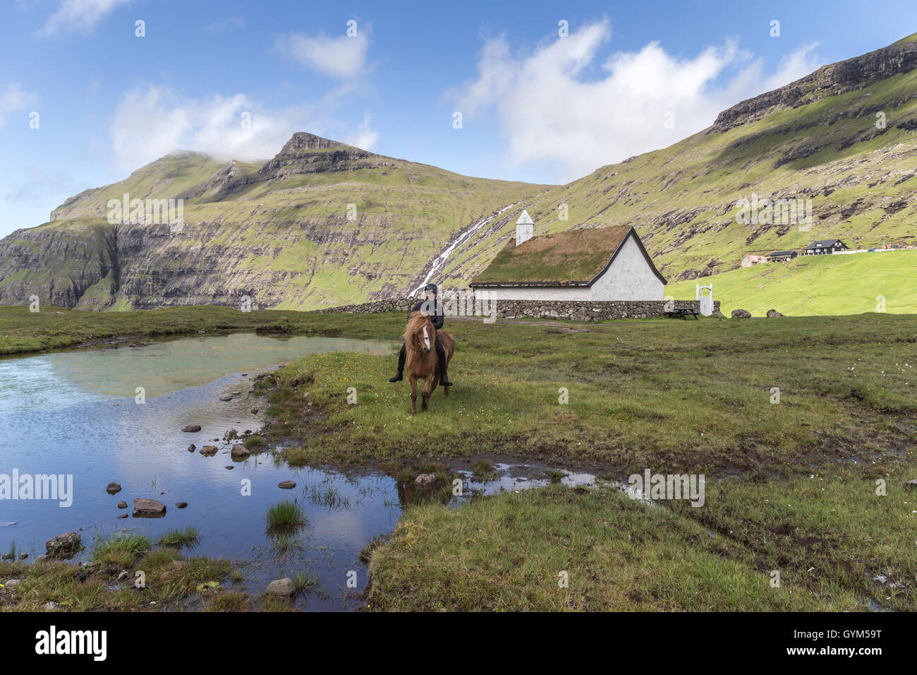 A Faroese girl with her horse in Saksun, Island of Streymoy. Faroe Islands Stock Photo