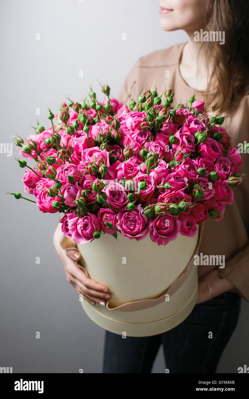 Luxury bouquets of flowers in the hat box. roses in the hands women