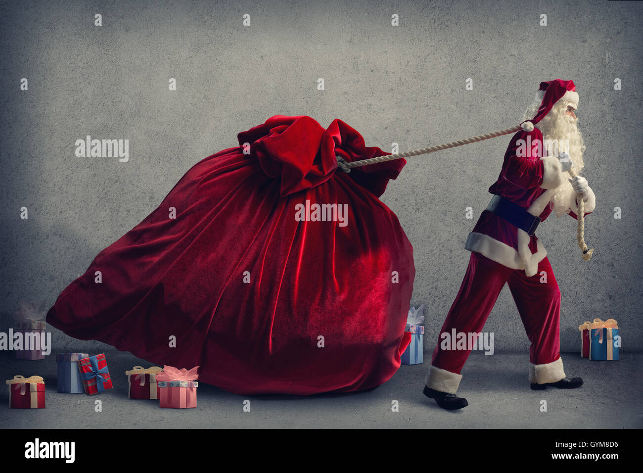 Santa Claus pulls a huge bag of gifts Stock Photo - Alamy