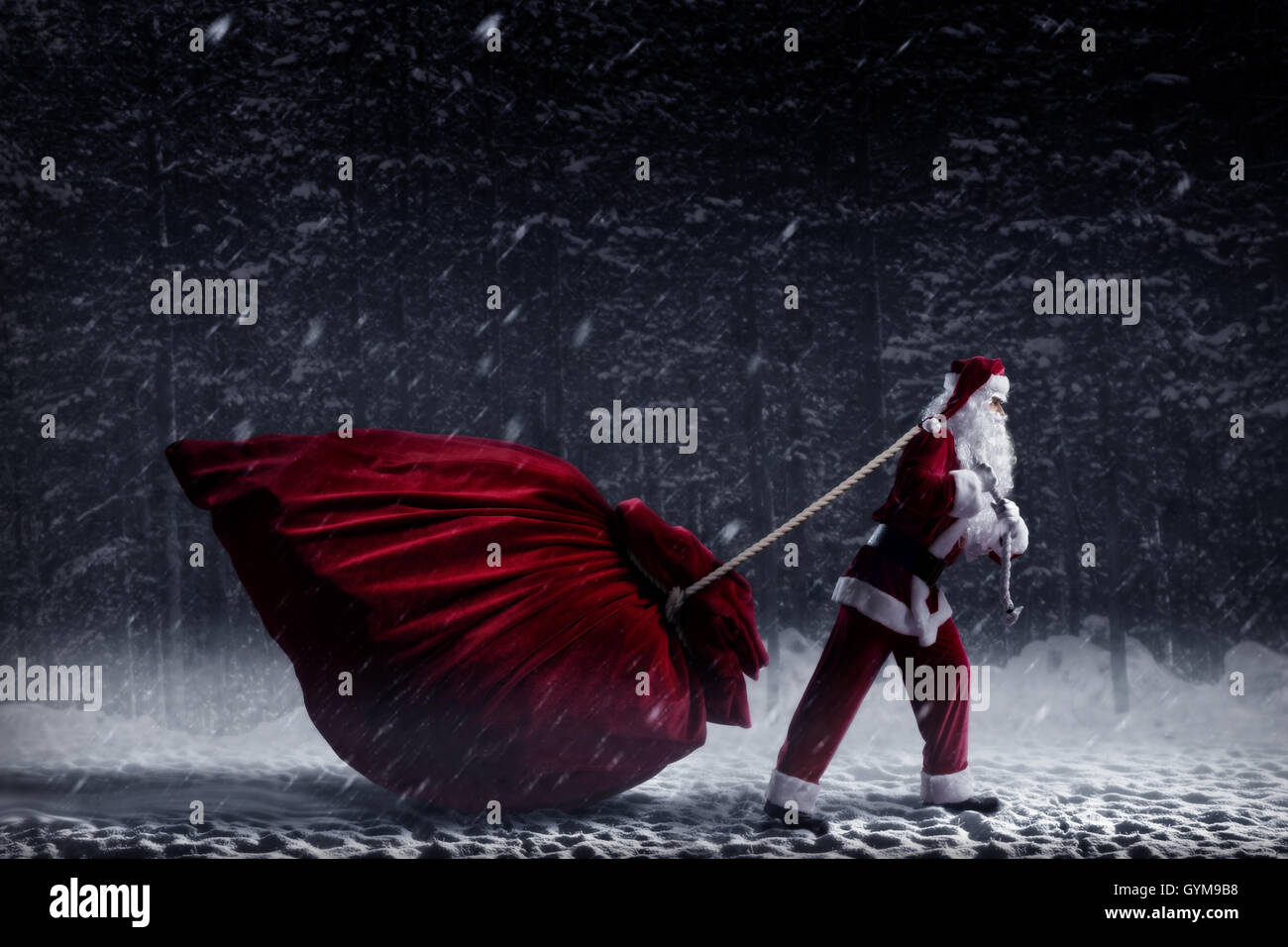 Santa Claus pulls a huge bag of gifts Stock Photo - Alamy