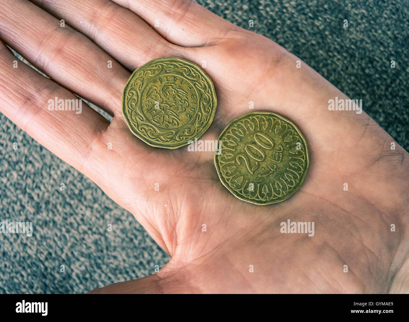 Two Tunisian coins on the woman's palm Stock Photo