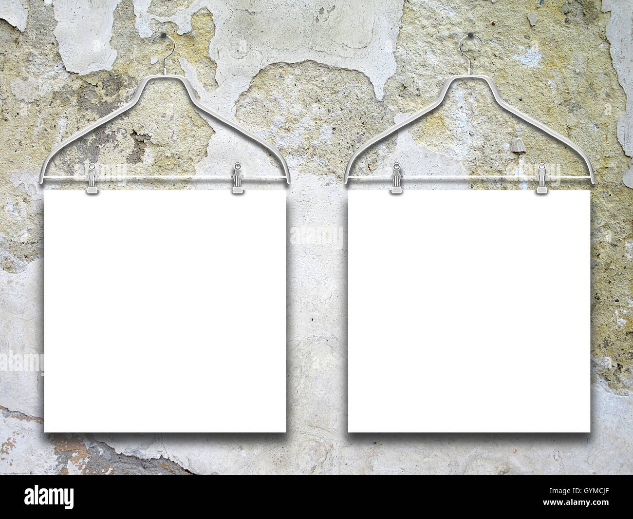 Close-up of two square blank frames hanged by clothes hangers against scratched concrete wall background Stock Photo