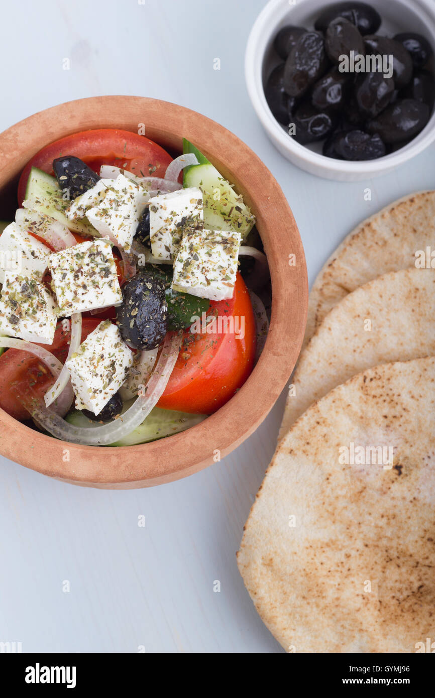 Greek salad in a clay pot with pitas and appetizers Stock Photo Alamy