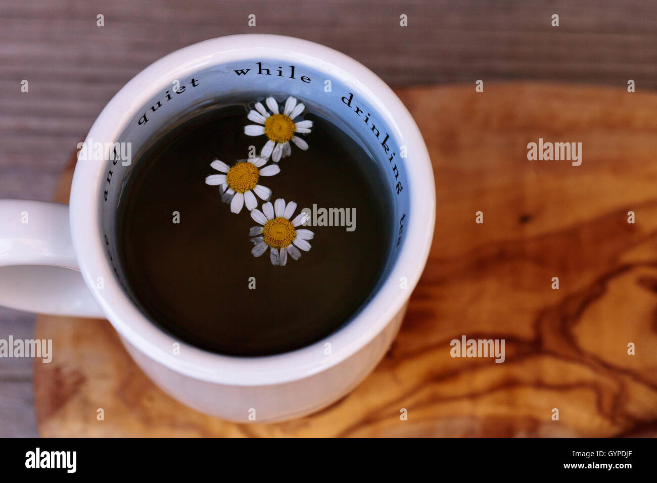 Chamomile tea with chamomile daisy flowers in a hot white cup on a ...