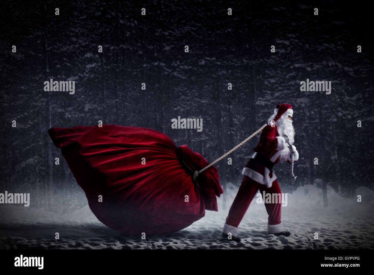 Santa Claus pulls a huge bag of gifts Stock Photo - Alamy
