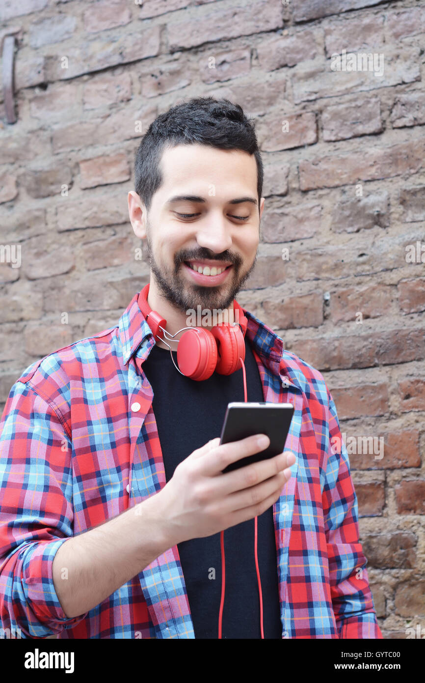 Casual young latin man using a smartphone. Stock Photo