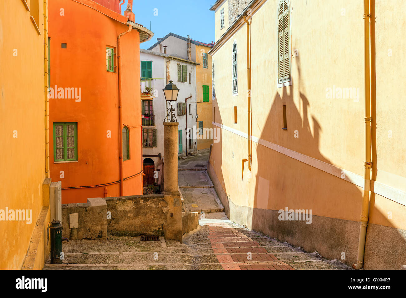 Narrow street among colorful houses in old town of Menton, France. Stock Photo
