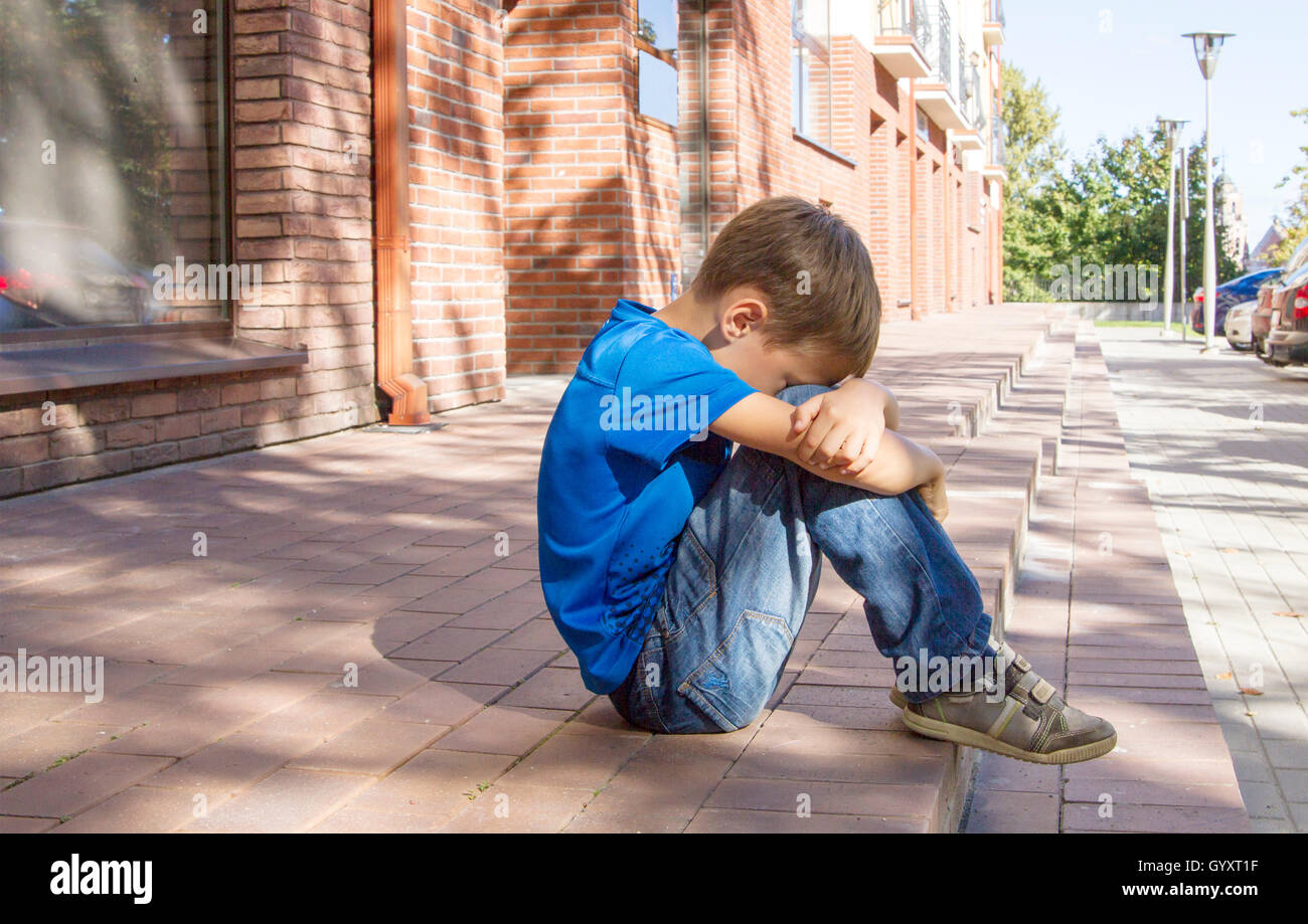 Sad, lonely, unhappy, disappointed child sitting alone on the ...