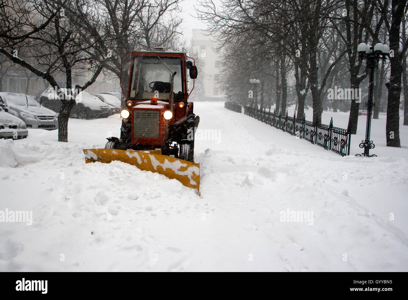 Tractor clearing snow during snowfall Stock Photo Alamy