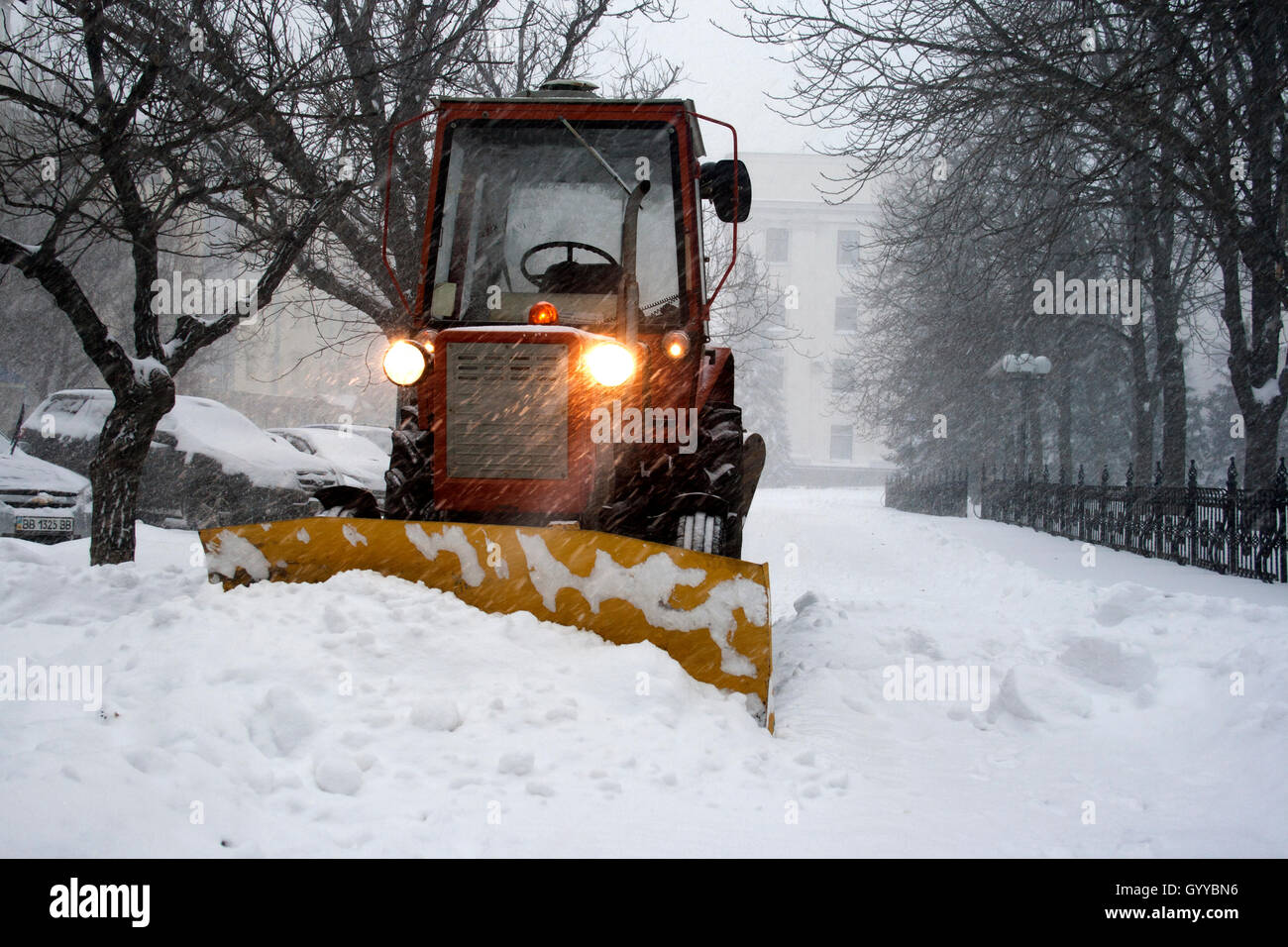 Tractor clearing snow during snowfall Stock Photo Alamy