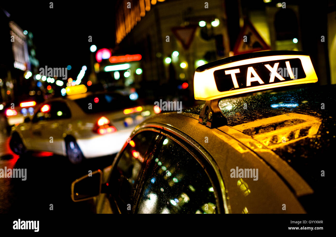 Sign of taxi lights at night and reflects in the car roof, Berlin, Germany Stock Photo