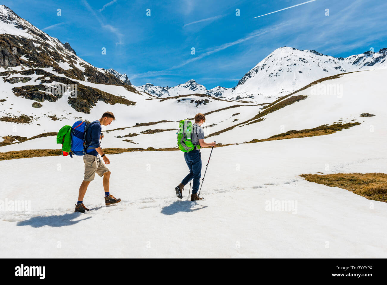 Two hikers walk over snowfield, Rohrmoos-Untertal, Schladming Tauern, Schladming, Styria, Austria Stock Photo