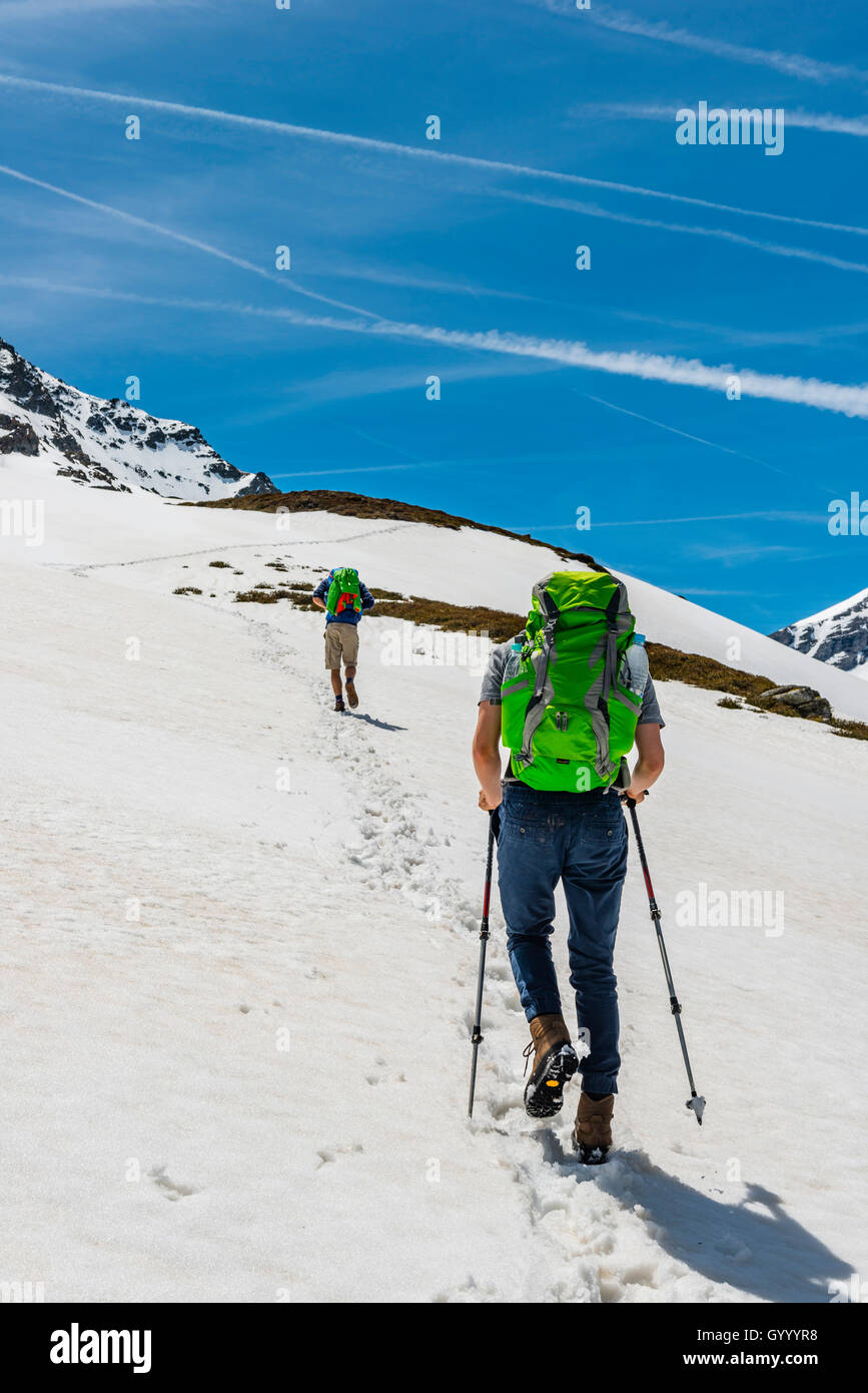 Two hikers walk over snowfield, Rohrmoos-Untertal, Schladming Tauern, Schladming, Styria, Austria Stock Photo